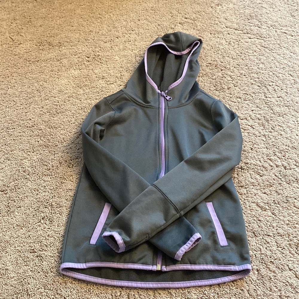 Zip up jacket. Has thumb holes in the sleeves.